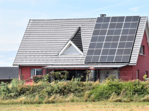 Rotes Haus mit Photovoltaik auf dem Dach