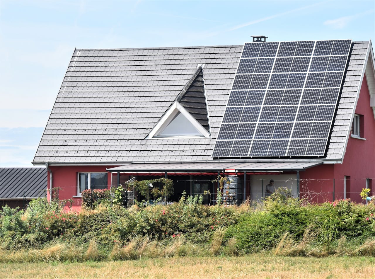 Rotes Haus mit Photovoltaik auf dem Dach