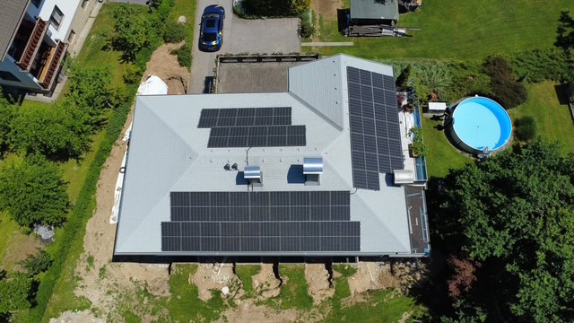 Drohnenaufnahme des Einfamilienhauses in Niederösterreich mit Photovoltaik-Modulen in Süd-, West- und Ostausrichtung auf neuem Bitumendach