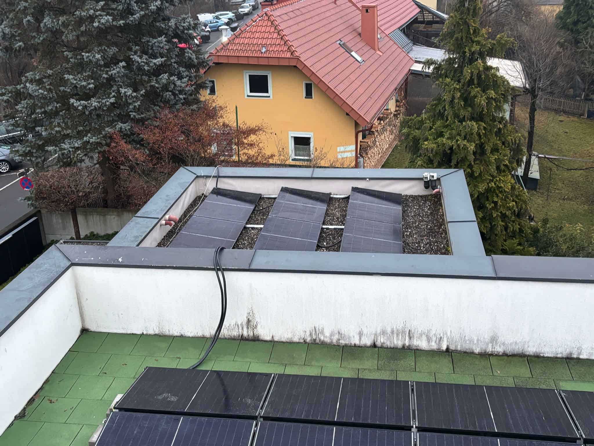 Flachdach des Stadthauses in Graz mit aufgeständerten Glas-Glas-Modulen in Süd- und Ostausrichtung