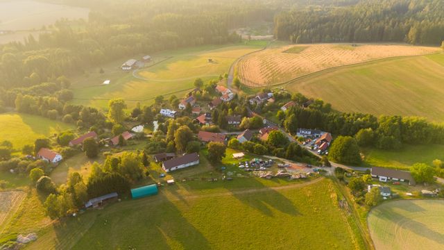Erneuerbare Energie in der Region: Windräder und Felder unter einem Regenbogen