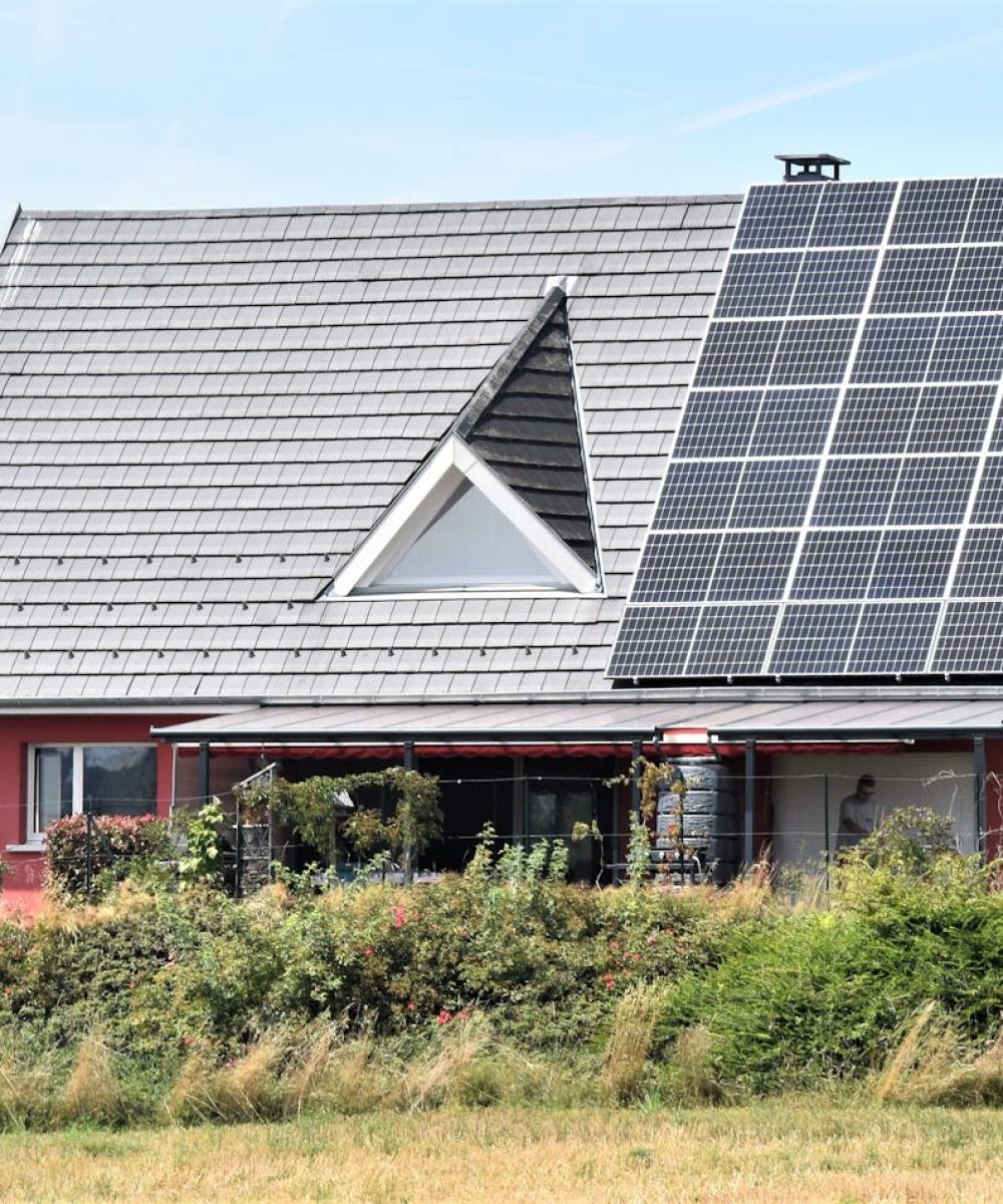 Rotes Haus mit Photovoltaik auf dem Dach