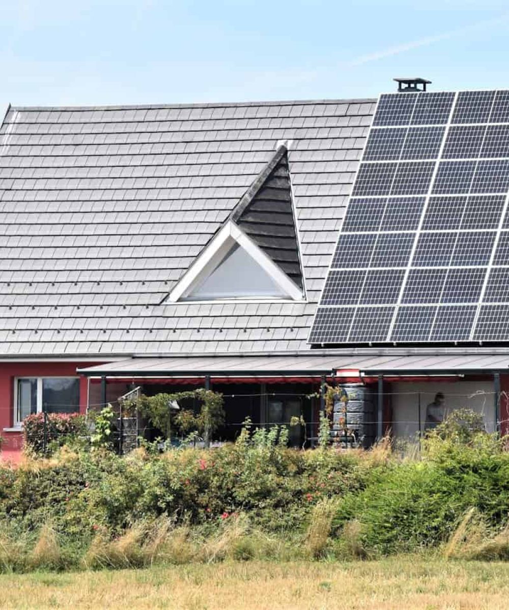 Rotes Haus mit Photovoltaik auf dem Dach
